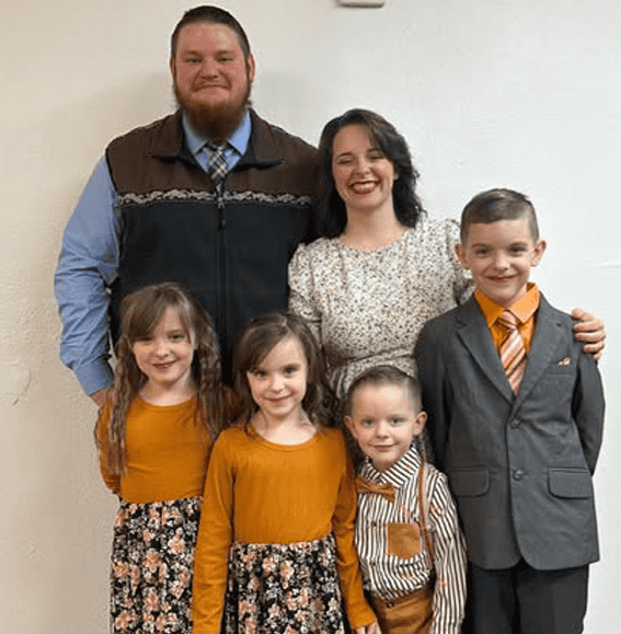 Family picture with Dad, Mom three girls and a boy in coordinated outfits of orange and grey
