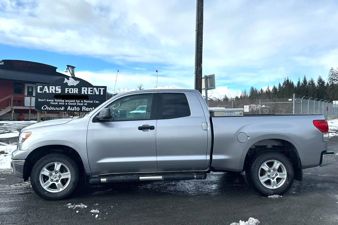 Cars for Rent = Don't keep fishing around for a rental car - hook into a good deal at Chinook Auto Rental - sign behind silver pickup with 4 doors