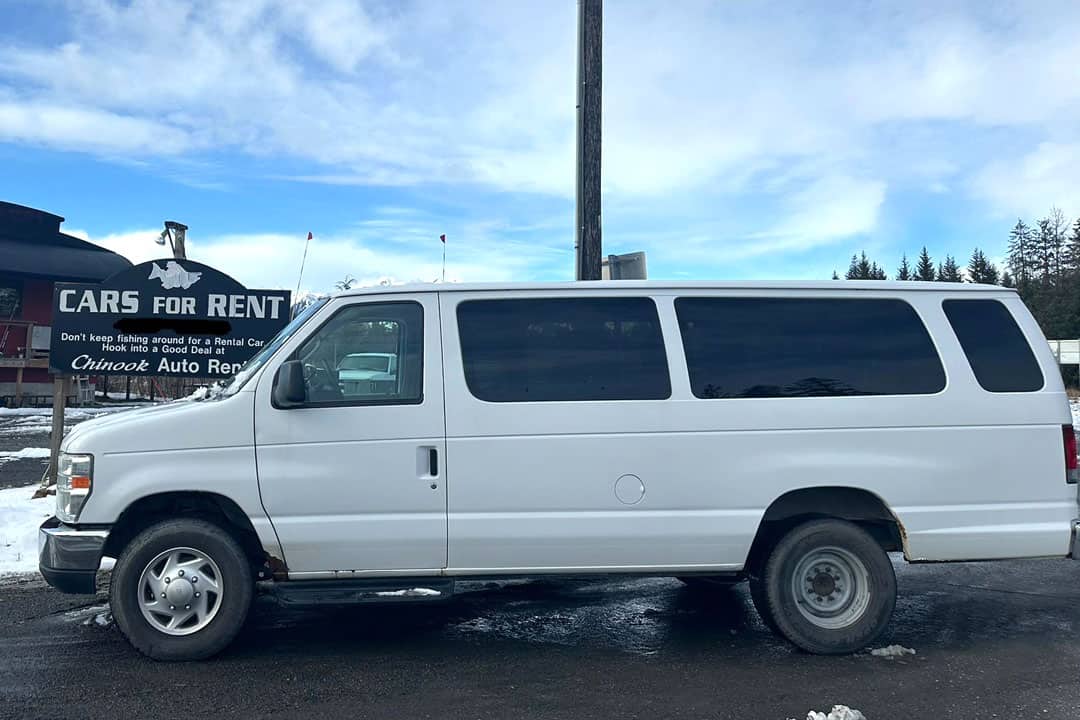 Cars for Rent = Don't keep fishing around for a rental car - hook into a good deal at Chinook Auto Rental - sign behind the large white passenger van.